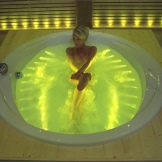 Tyttö kylpyammeessa keltaisella taustavalolla