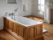 Badkar i gjutjärn som döljs av träskärmar