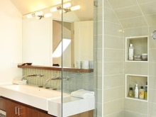 A mirror with a shelf built into the bathroom wall