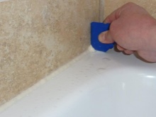 Sealing gaps between the bathtub and the wall with silicone sealant