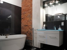 Illuminazione a specchio in stile loft nel bagno con pareti di mattoni combinati