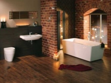 Illuminazione non illuminata in un bagno spazioso in stile loft con pareti di mattoni e impianto idraulico bianco