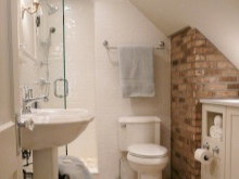 Muri combinati di mattoni, intonaco e piastrelle nel bagno in stile loft