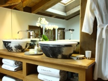 Tvättställsskåp i trä med diskbänkar av sten i ett badrum i chaletstil