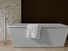 Rectangular freestanding white bathtub with floor standing mixer tap