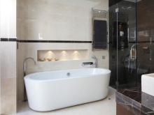 Осветена ниша до ваната като рафт за аксесоари.