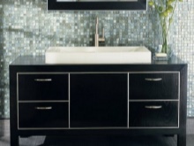 Black floor standing cabinet with metal handles on drawers and large white built-in sink