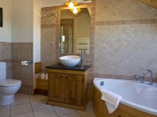 Suuri työtason lattiakaappi ja seinään asennettava pesuallas kylpyhuoneessa, johon on yhdistetty wc.