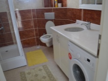 Εντοιχισμένο ντουλάπι με πάγκο εργασίας και εντοιχισμένο νιπτήρα για το πλυντήριο ρούχων στο μπάνιο