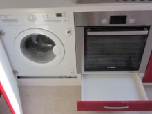 Punaiseen keittiöön rakennettu pesukone