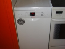 Un lave-linge à chargement vertical sous le plan de travail à charnière