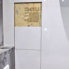 Facing with ceramic tiles homemade inspection hatch in the bathroom