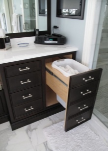 Dark-colored bathroom cabinet with pull-out laundry basket