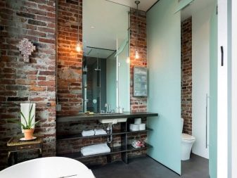 Bagno in stile loft - muri di mattoni non finiti, divisori in vetro, grande specchio