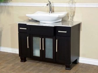 Svart MDF-skåp med glasdörrar och vitt handfat i badrummet