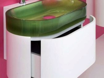 Halvcirkelformigt vit skåp i plast med gångjärn och ett handfat i frostat grönt glas i badrummet