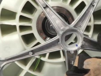 Разглобяване на частите на пералната машина за отстраняване на лагера от барабана