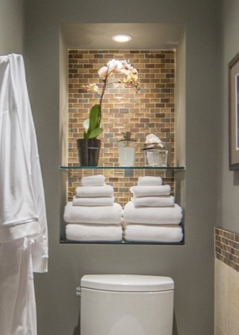 Разположението на дълбока ниша с осветление и рафт над тоалетната чиния.