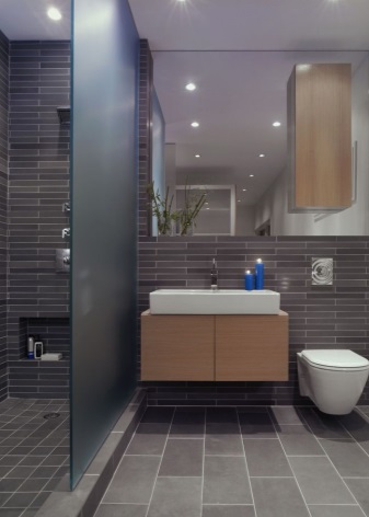 Hanging cabinet with sink located between the shower and toilet