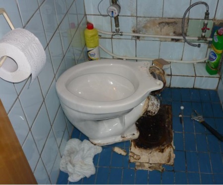 Demontering av en toalett installerad på betong