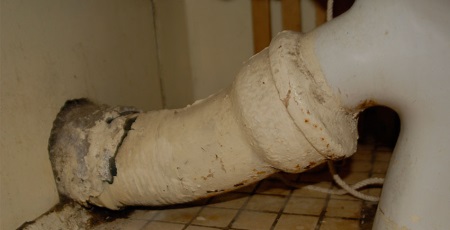 Gammal toalett och gjutjärnsrör