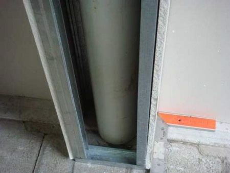 Makeshift box for pipes in the middle of the bathroom wall