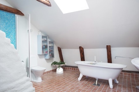 Des carreaux de céramique bleus, rouges et blancs pour les murs et le sol dans une salle de bains de style scandinave.