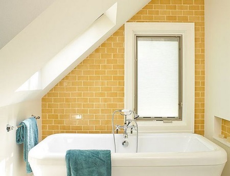 Bagno in stile loft con mattoni e pareti imbiancate, con accenti luminosi sotto forma di asciugamani colorati