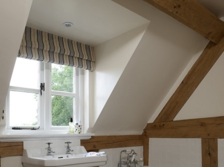 Travi di legno sulle pareti intonacate e sul soffitto del bagno in stile loft