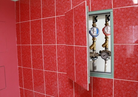 Sanitary revision hatch invisible tile trimmed with red ceramic tiles