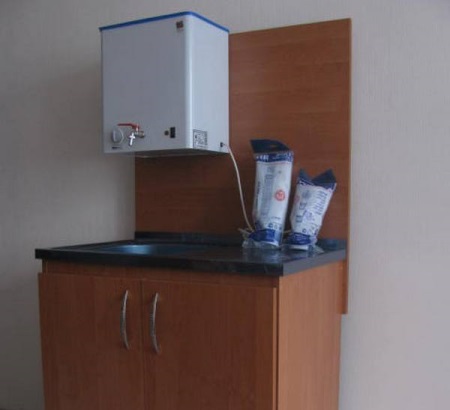 Vaskemaskine på en bred skuffe med vandvarmetank til sommerhus eller have