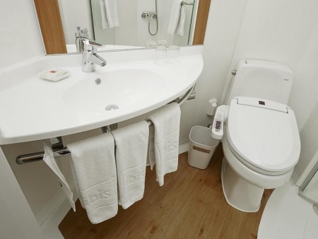 Valkoiseen kylpyhuoneen sisustukseen sopivat saniteettitarvikkeet yhdistettynä wc:hen.