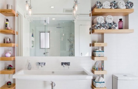 Puuhyllyt valkoisessa kylpyhuoneessa yhdistettynä wc:hen