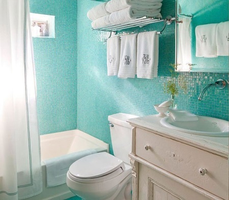 Turkoosi mosaiikki kylpyhuoneen sisätiloissa yhdistettynä WC:hen, jossa on valkoiset kalusteet ja saniteettilaitteet