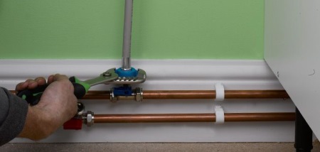 Cutting a tee into a metal pipe to connect the washing machine to the water supply